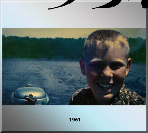 Photo of Jerry Michelsen in 1961 driving a motor boat at ten years of age. Background is blue lake and green trees. Jerry has a smile a mile long.