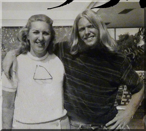 Photo of Jerry Michelsen standing with his mother. Jerry has long, blond hair and red mutton chop sideburns. The photo is from nineteen seventy.