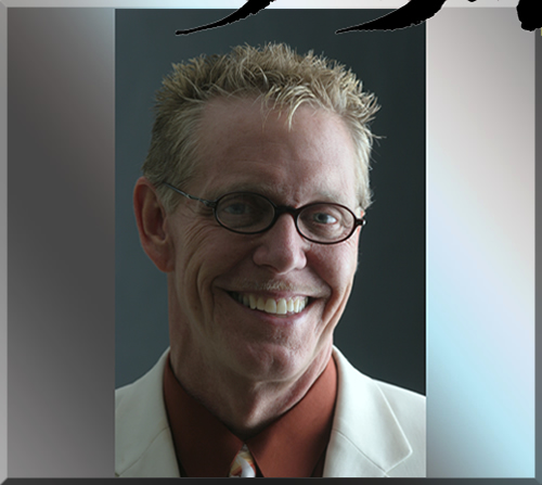 Jerry Michelsen in a white suit smiling and wearing glasses