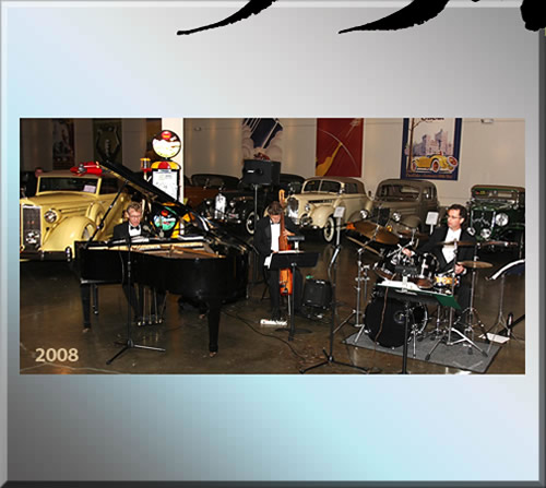 Photo of The Jerry Michelsen Trio in two thousand eight playing in a museum of classic, antique cars.