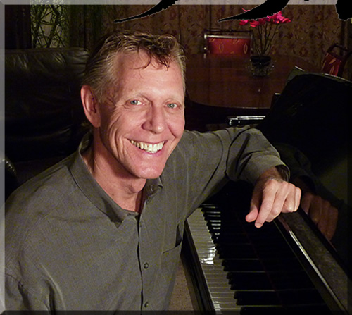 Jerry Michelsen with arm on a grand piano, smiling